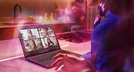 Une femme fait des gestes alors qu'elle dirige une visioconférence sur un portable Lenovo ThinkPad X9.