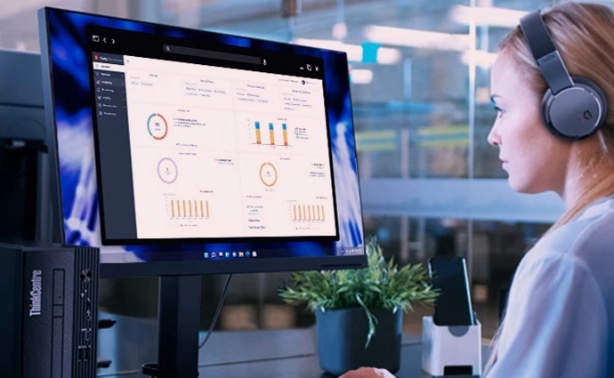 A person working on a Lenovo monitor & analyzing data via audio-visual form.
