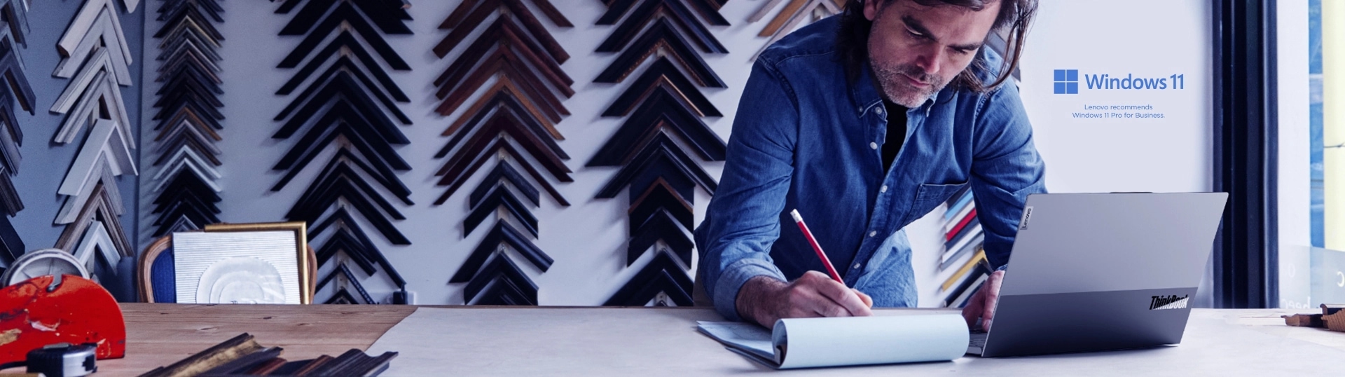 Designer working on Thinkbook with lid open