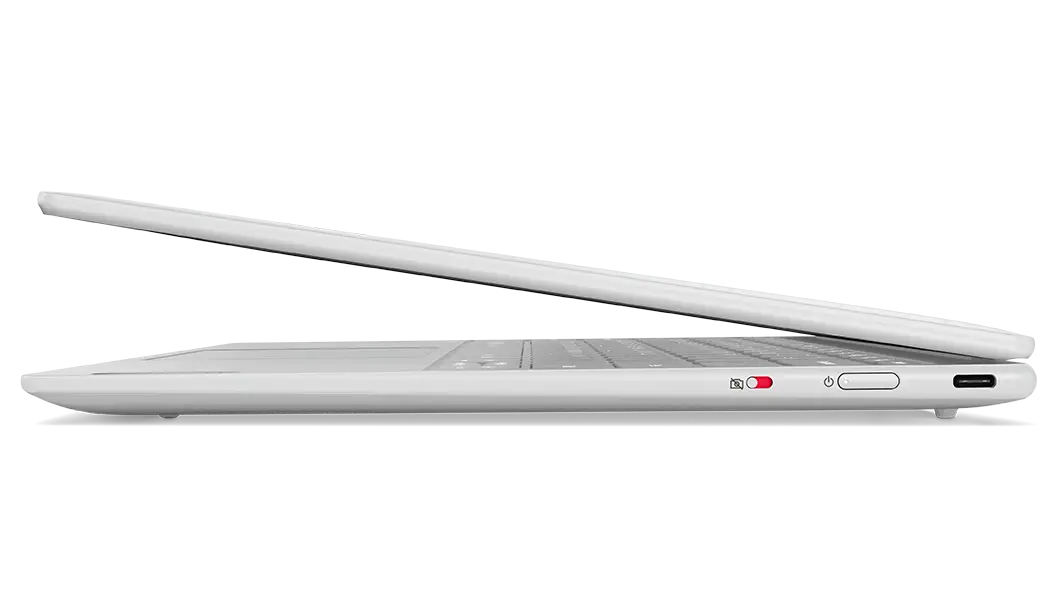 Side profile of Yoga Slim 7i Carbon laptop, opened 45 degrees, showing edges of top & rear covers, part of keyboard, & right-side ports