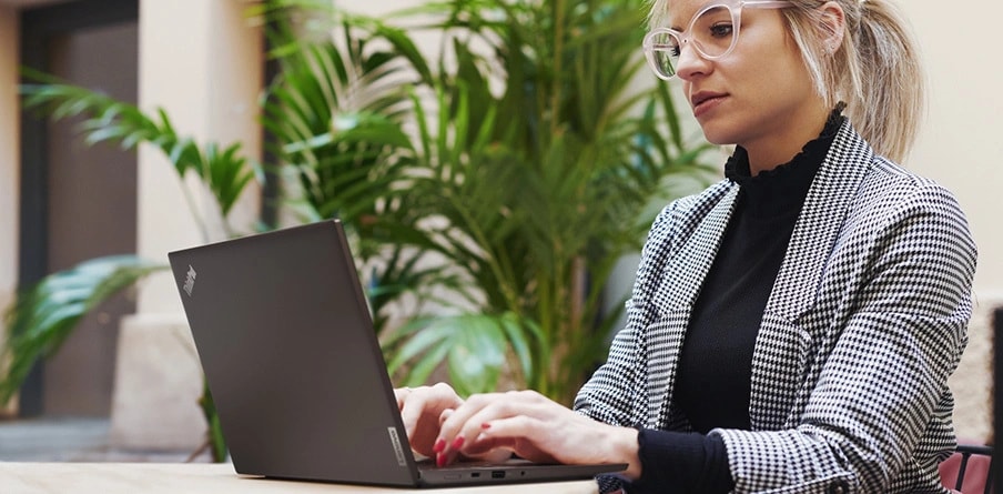 A woman working on a Lenovo ThinkPad L13 Gen 5 laptop driven to boost productivity.