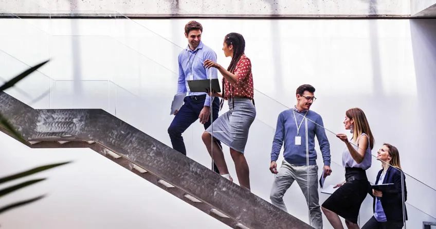 A group of people talking with walking up a staircase