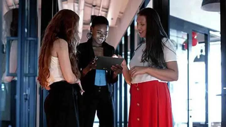 Trois femmes au travail en collaboration avec une tablette