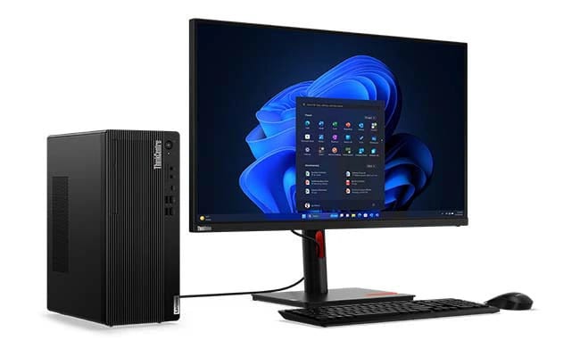 Lenovo ThinkCentre M70t Gen 5 Tower-Desktop von links mit Anschlüssen und Steckplätzen, an einen Monitor angeschlossen, mit einer Funktastatur und einer Maus.