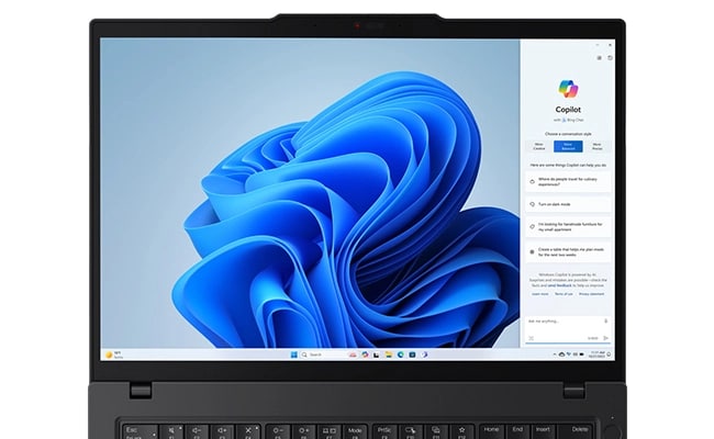 Cut-short view of the Lenovo ThinkPad T14 Gen 5 (14” AMD) Eclipse Black laptop opened 180 degrees, focusing its 14 inch display with a wallpaper & a Windows Copilot menu opened on the screen.