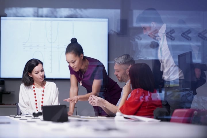 Five colleagues in a conference room solving a problem