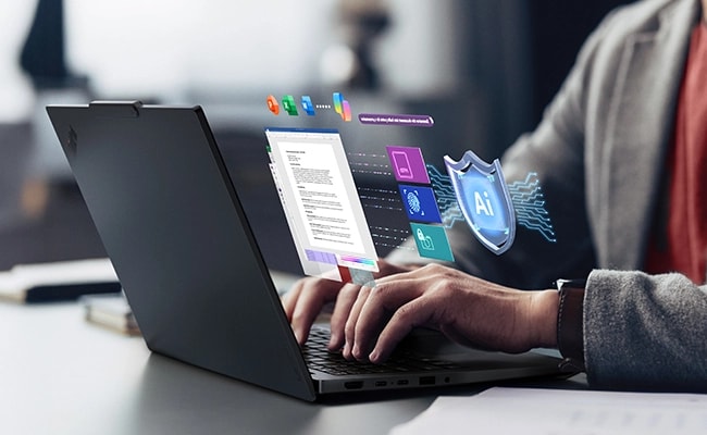 Zwei Hände, die auf einem Lenovo ThinkPad E14 Gen 7 (14" Intel) Notebook auf einem Schreibtisch tippen – Ansicht von hinten von links mit App-Bildschirmen und einem KI-Schild-Symbol, das aus dem Display zu kommen scheint.