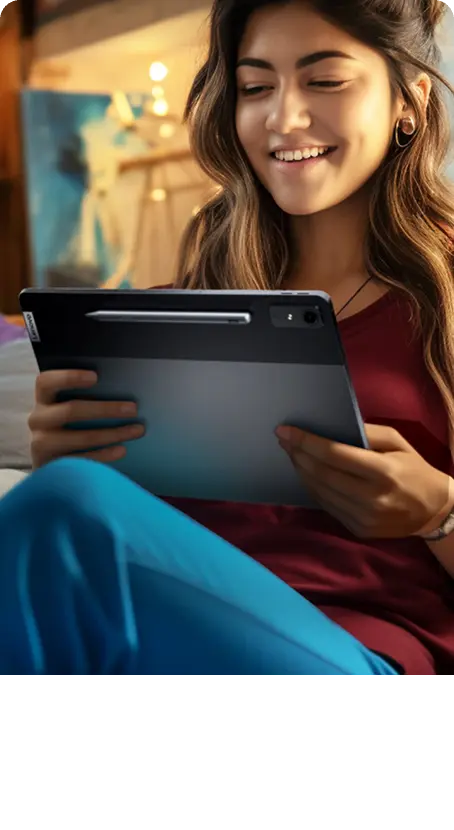 A woman dances joyfully while listening to music on her tablet.