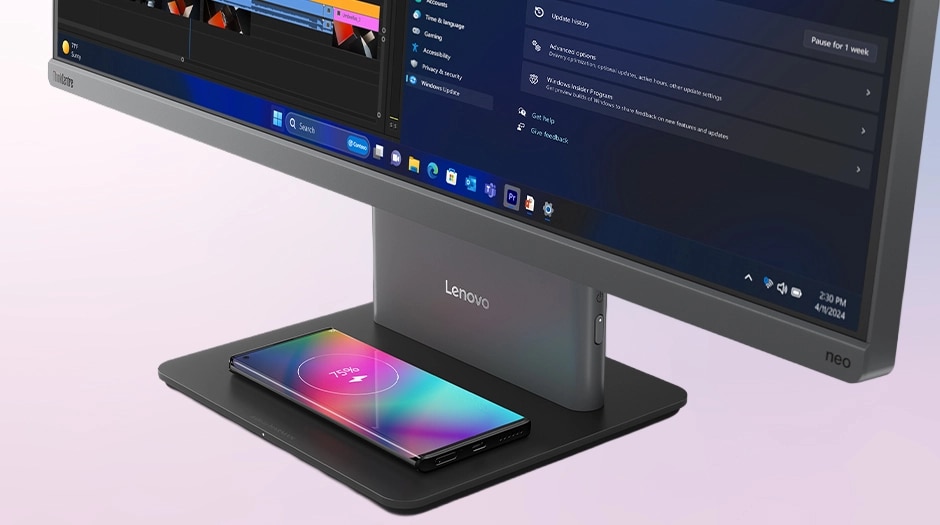 Phone charging on the optional wireless charging stand base beneath the display of Lenovo ThinkCentre Neo 50a Gen 6 (24" Intel) AIO PC.