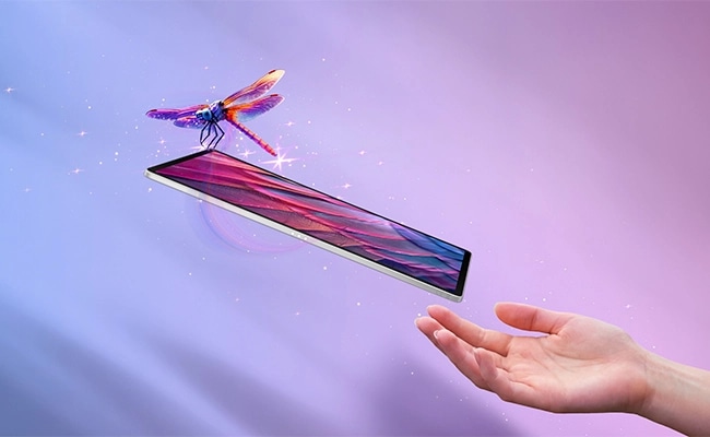 Una libélula se cierne sobre una tableta flotante delgada, con una mano extendiéndose, resaltando la tableta Lenovo Idea TAB Pro Gen 2.