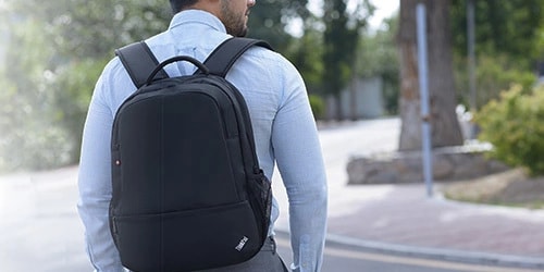 Man walking on the street with a Thinkpad black backpack.