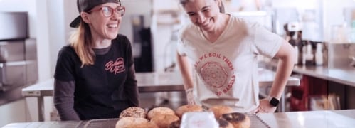 Two ladies in a bagel shop laughing