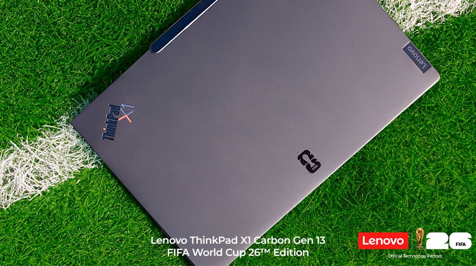The closed laptop on a soccer field, with ThinkPad X1 & FIFA World Cup 26 logos on the Lenovo ThinkPad X1 Carbon Gen 13 Aura Edition FIFA World Cup 26 Edition.
