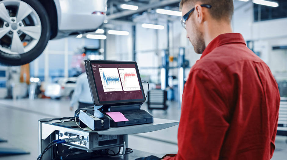 A technician in a car repair workshop analyzes data on the Lenovo ThinkTab X11 tablet.