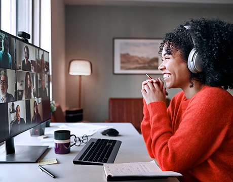A woman collaborating via a video call on a desktop monitor powered by the Lenovo ThinkStation P5 Gen 2 (Intel) tower.