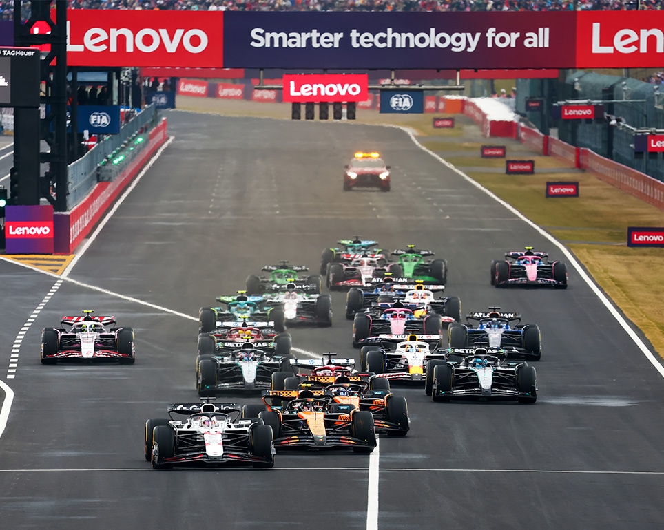 Un grupo de autos de carreras F1 en una pista con el logotipo de Lenovo en el fondo.