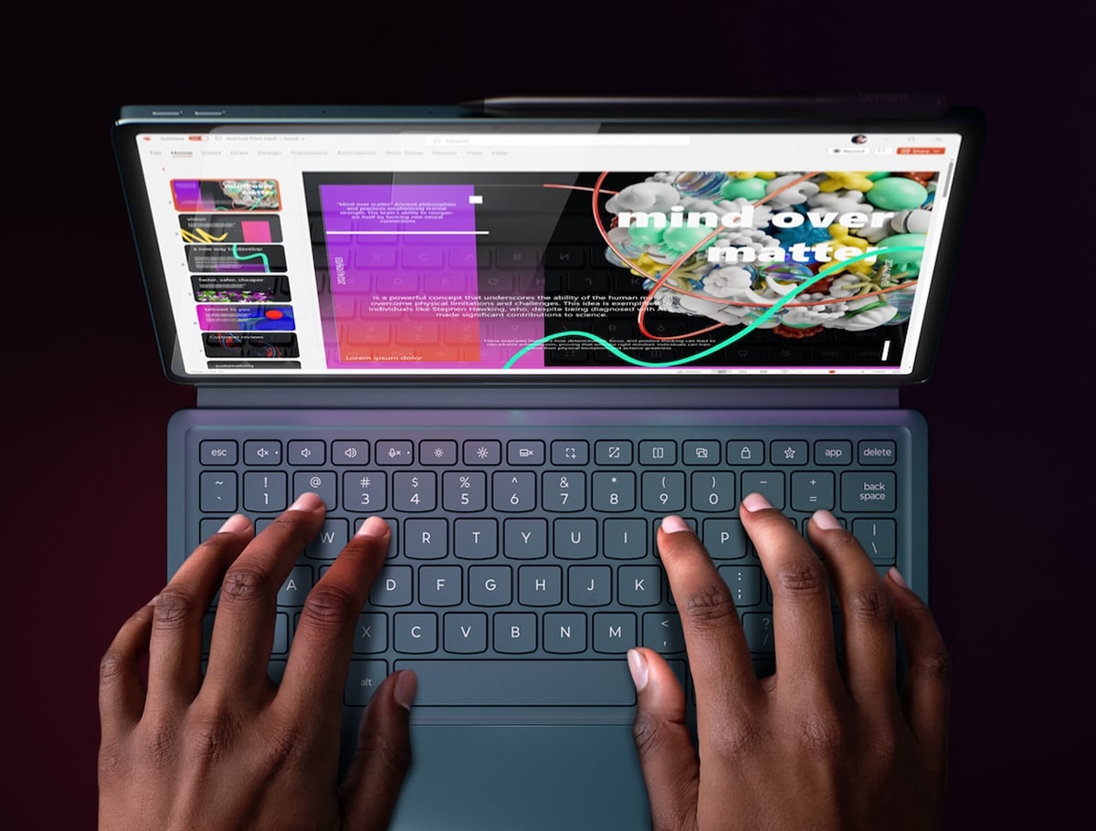 L’utilisateur tape sur le Lenovo Yoga Tab Plus attaché à un clavier de taille standard avec une interface multitâche colorée.