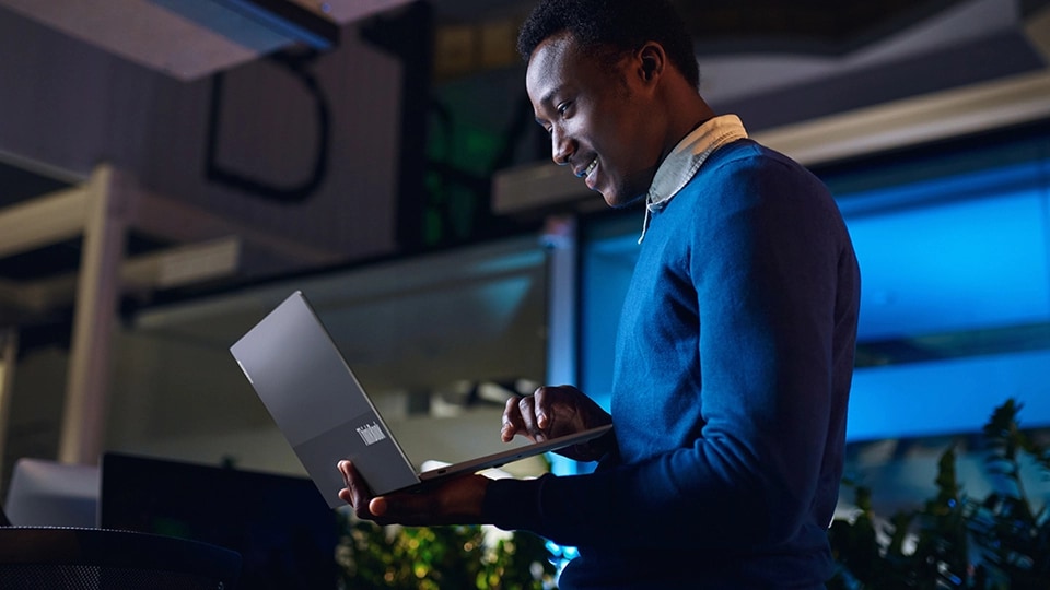 Una persona trabajando en un ThinkBook 13x de 2.ª generación mientras está de pie en una oficina moderna