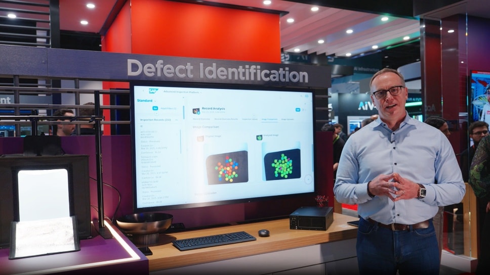Homme au kiosque technique montrant le logiciel d’identification des défauts sur un grand écran.