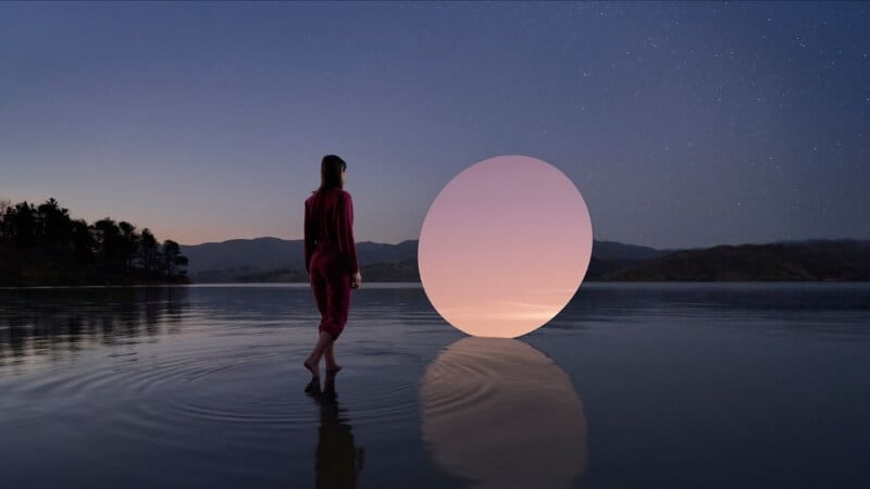 A woman walking toward a colorful portal located in the middle of a lake.