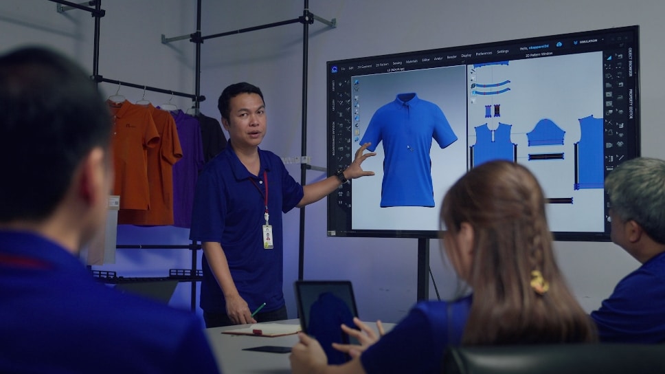 People in a conference room examining apparel on a large screen