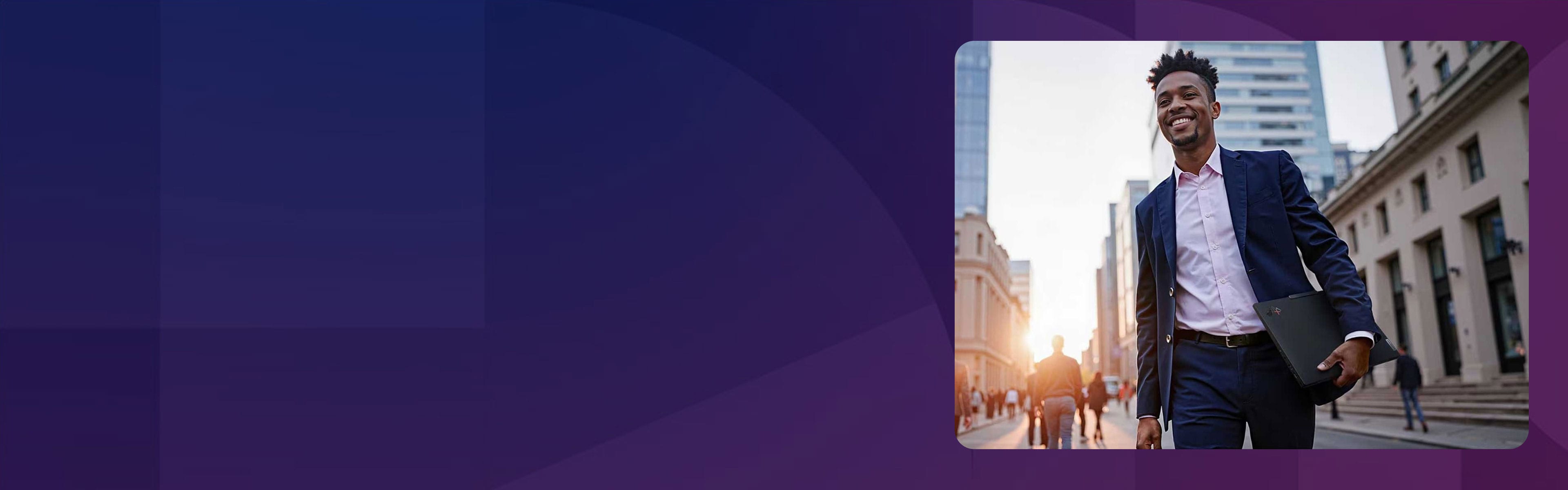 A man in a business suit holding a laptop and walking down a city street.