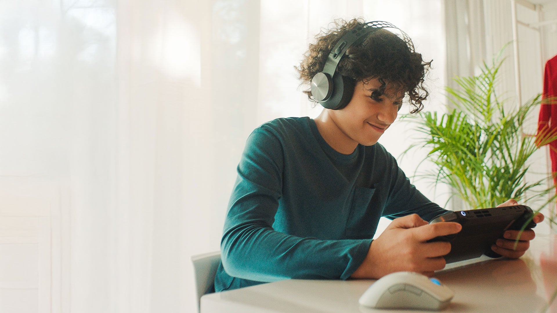 A kid playing on a Lenovo Legion Go and wearing headphones.