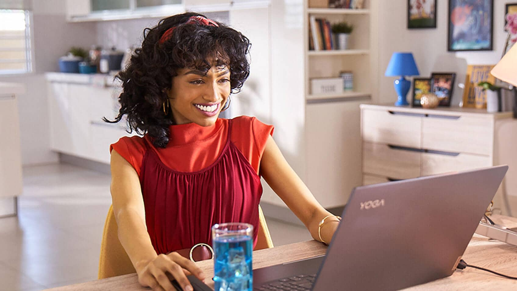 A smiling woman using her laptop at home