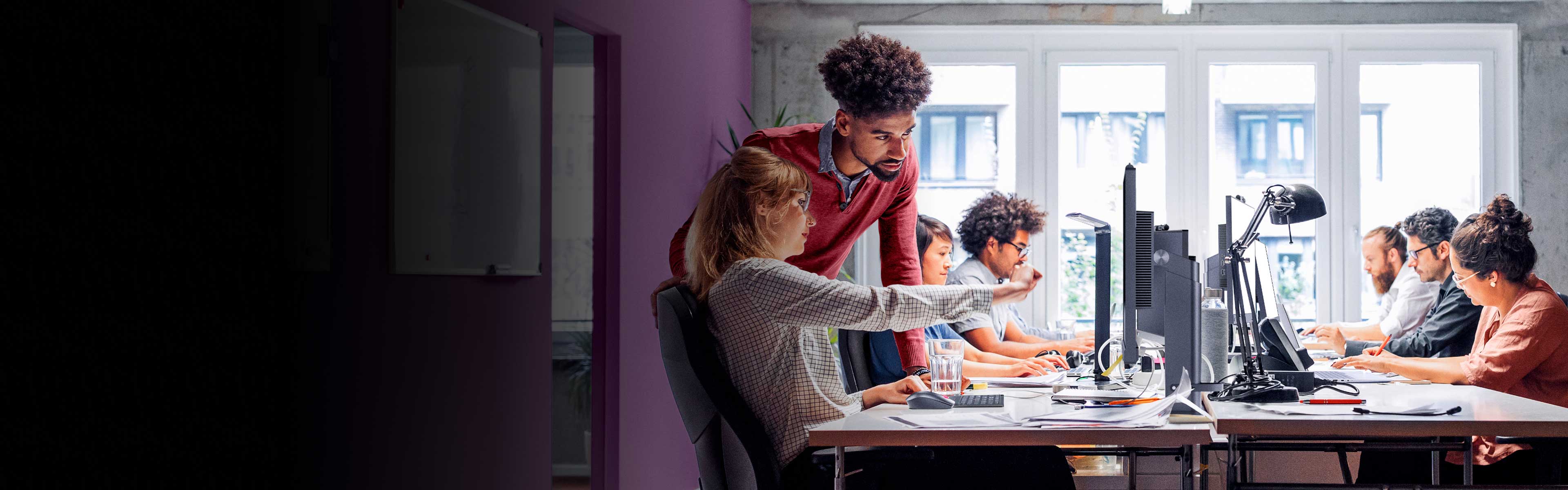 Two rows of people sitting at their computers working.