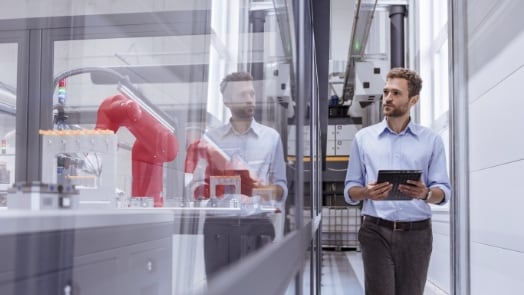 A man with a tablet examining robotics in a laboratory