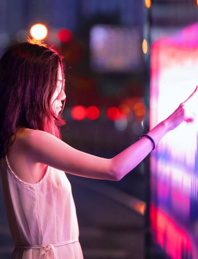 A woman interacting with a futuristic display.