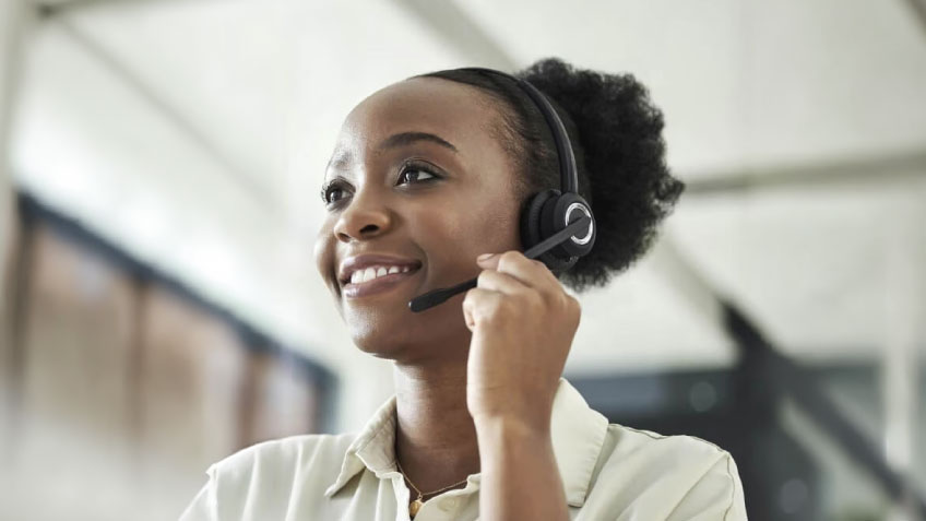 A woman smiling while using a headset