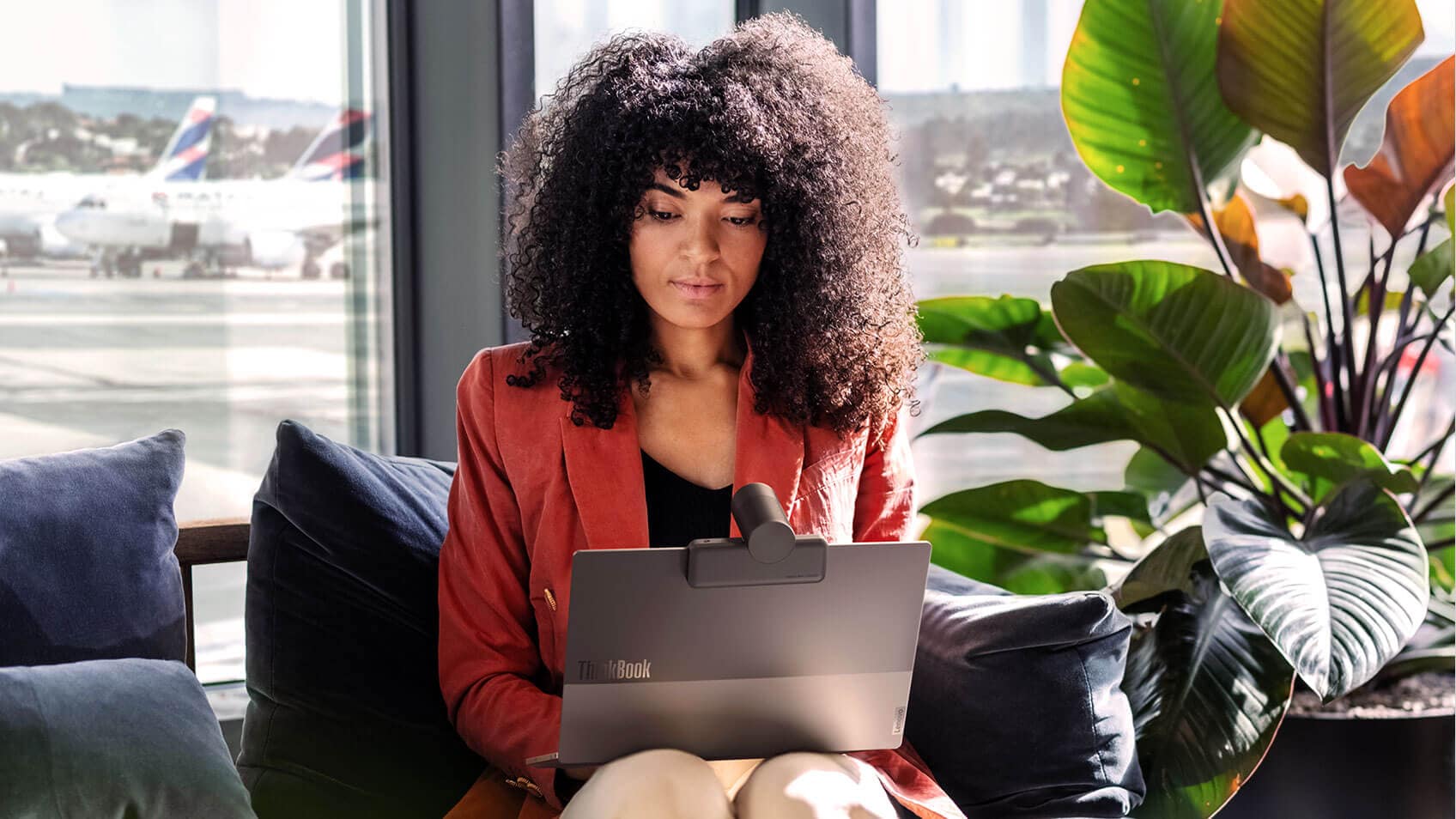 A woman in an airport lounge using her laptop