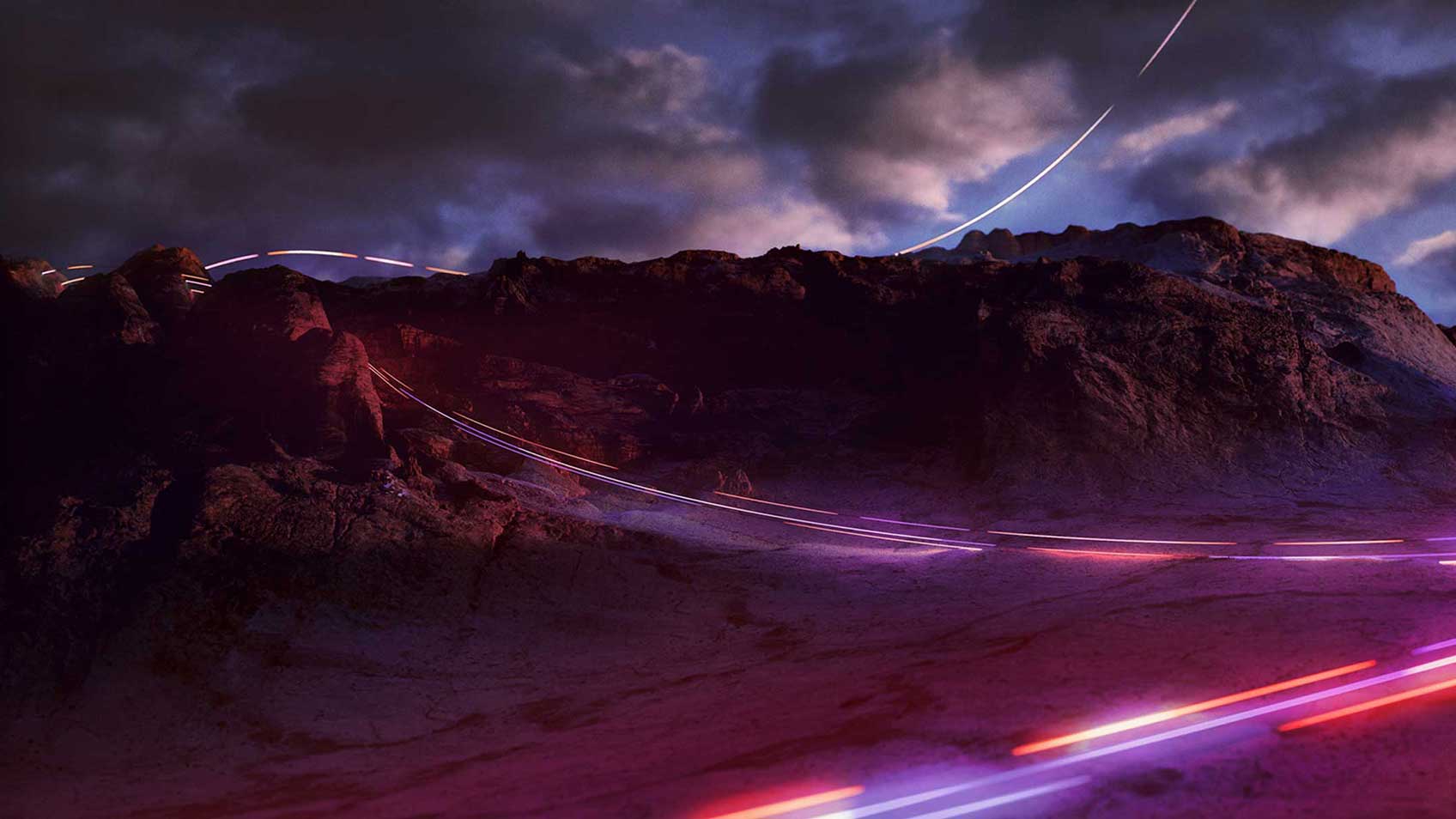 A time laps of cars at dusk zipping around a rocky mountain.
