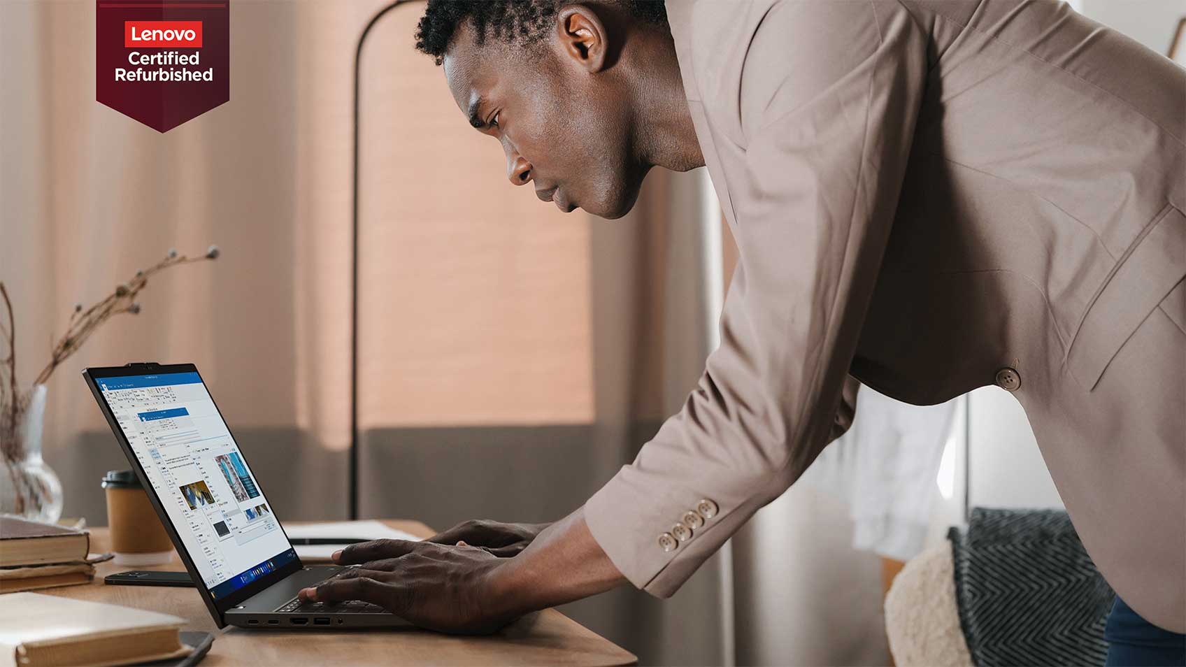  A man bending over to type on his laptop.