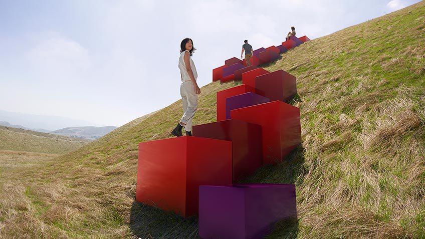 Red and purple boxes leading up a hill like a staircase, with three people ascending them 