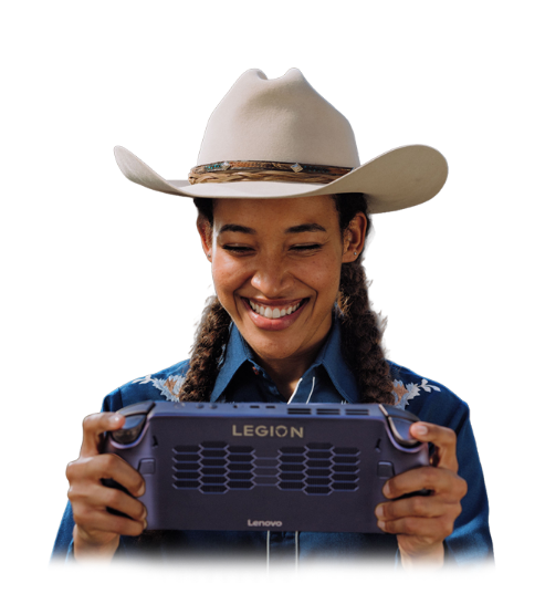 Personne souriante dans un chapeau de cowboy retenant un ordinateur portable de jeux Lenovo Legion Go, avec le logo Legion en arrière-plan.