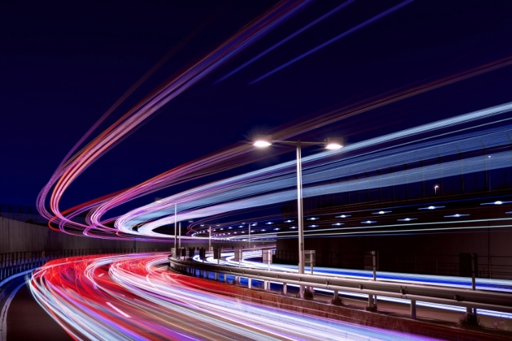 Long-exposure shot of a highway at night, capturing dynamic motion with light trails.