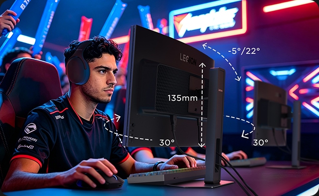 Gamer using a Legion 34w-2c monitor with adjustable stand (135mm height, ±30° swivel, -5°/22° tilt) in a vibrant esports arena.
