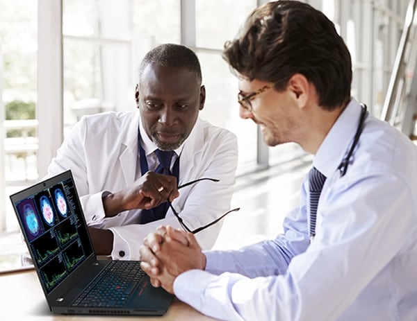 Two doctors examining x-rays on the screen of a ThinkPad T15p Gen 3 (15" Intel) mobile workstation on a desk