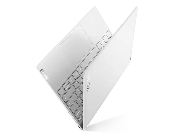 Aerial view of Yoga Slim 7i Carbon laptop at angle, opened 45 degrees in  a V-shape, showing top cover, part of keyboard, & right-side ports