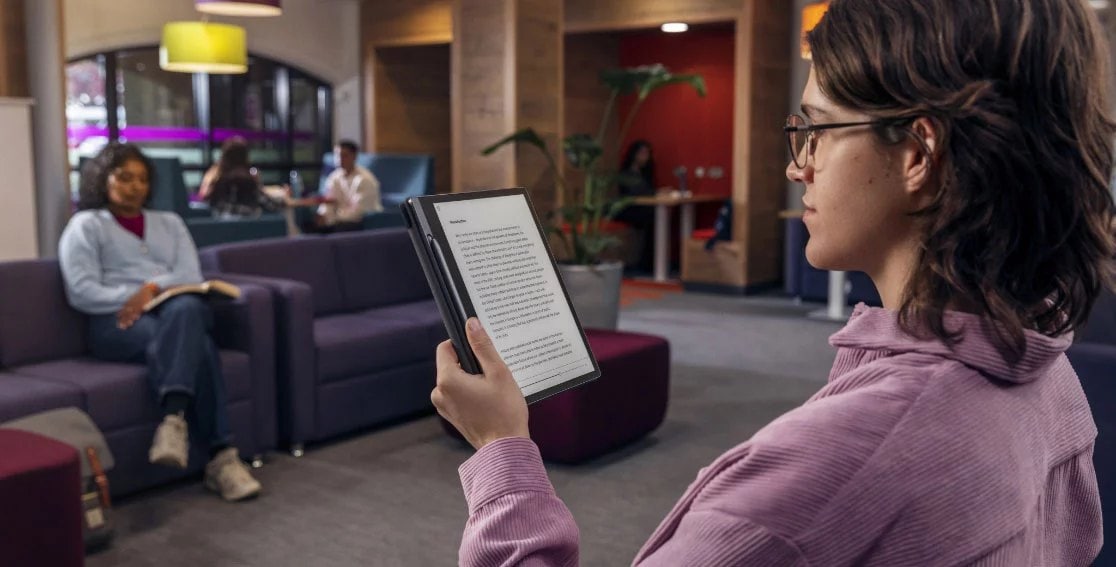 Person holding Lenovo Smart Paper E-Ink reader vertically, reading an e-book on screen