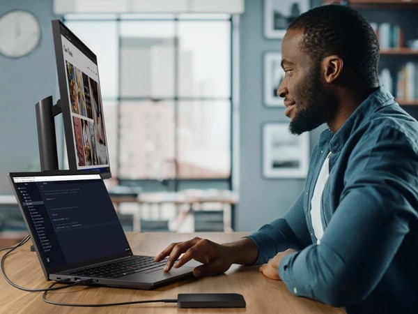 Person sitting at desk in home studio, facing ThinkPad E14 Gen 5 (14